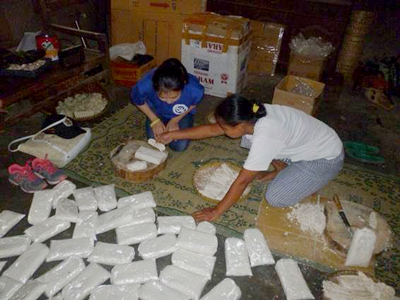 フィリピンプロジェクトで「カラムンガイ」を粉末にし、袋詰めにする作業の様子