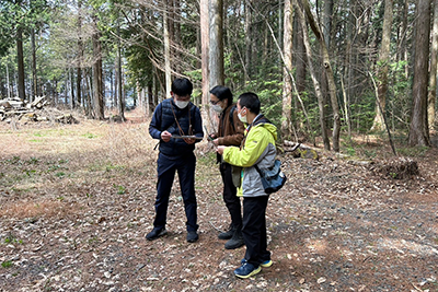 森の探索と音声ガイドを元にしたクイズを楽しむ参加者たちの様子。 森の探索と音声ガイドを元にしたクイズを楽しむ参加者たちの様子。